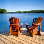 两把阿迪朗达克椅子坐在俯瞰湖泊的码头上